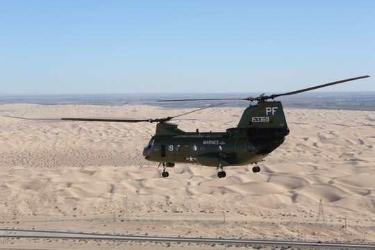 A CH-46E Sea Knight with Marine Medium Tiltrotor Squadron (VMM) 364 flies over rolling sand dunes on its way to Davis-Monthan Air Force Base, Ariz., Oct. 29. The squadron painted the aircraft to resemble its original colors during the Vietnam War.