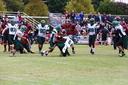 Two Daegu Warrior defensive players tackle Jason DeGrace, a Matthew C. Perry running back, during the 2014 Department of Defense Dependents Schools Far East Division II Football Championship Game at the Matthew C. Perry High School football field aboard Marine Corps Air Station Iwakuni, Japan, Nov. 8, 2014. DeGrace and the other Samurai running backs accounted for more than 500 rushing yards, but the Warriors still prevailed 60-50 to take the title.