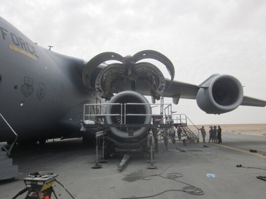 Aircraft Maintenance personnel, of the 8th Expeditionary Air Mobility Squadron, perform an engine change on a C-17A Globemaster III. During hi-risk maintenance operations, an increased focus on safety is critical not only to the security of the aircraft but also to the health of personnel. (Courtesy Photo)