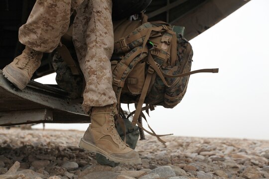 A Marine wearing Rugged All Terrain boots disembarks from a helicopter in Afghanistan. Two pairs of RAT boots, a temperate variant and hot variant, like the ones pictured above, will be issued to Marine Corps recruits and officer candidates in their sea bags starting Dec. 1. 