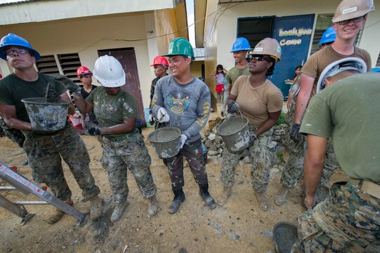 Armed Forces of the Philippines engineers, from the 552nd Engineer Construction Battalion, U.S. Navy Seabees, assigned to Naval Mobile Construction Battalion 5, and U.S. Marine engineers, from the 9th Engineer Support Battalion, are ‘shoulder-to-shoulder’ as they pass buckets filled with concrete for placement at Don Joaquin Elementary School in Tapaz, Philippines, during Balikatan 2015, April 9. The engineers, part of the Combined-Joint Civil-Military Operations Task Force located on the island of Panay, are constructing two classrooms at the school. Balikatan, which means “shoulder to shoulder” in Filipino, is an annual bilateral training exercise aimed at improving the ability of Philippine and U.S. military forces to work together during planning, contingency, humanitarian assistance and disaster relief operations.