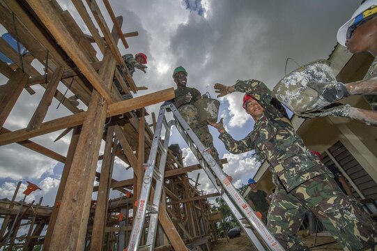 Armed Forces of the Philippines engineers, from the 552nd Engineer Construction Battalion, U.S. Navy Seabees, assigned to Naval Mobile Construction Battalion 5, and U.S. Marine engineers, from the 9th Engineer Support Battalion, are ‘shoulder-to-shoulder’ as they pass buckets filled with concrete for placement at Don Joaquin Elementary School in Tapaz, Philippines, during Balikatan 2015, April 9. The engineers, part of the Combined-Joint Civil-Military Operations Task Force located on the island of Panay, are constructing two classrooms at the school. Balikatan, which means “shoulder to shoulder” in Filipino, is an annual bilateral training exercise aimed at improving the ability of Philippine and U.S. military forces to work together during planning, contingency, humanitarian assistance and disaster relief operations. 