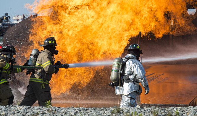 Firefighters from the 23rd Civil Engineer Squadron and the Valdosta Fire Department (VFD), douse the flames before entering a simulated aircraft during joint aircraft training April 8, 2015, at Moody Air Force Base, Ga. The VFD firefighters complete the required annual training to receive certification to support an aircraft fire at the local airport. (U.S. Air Force photo/Airman 1st Class Ceaira Tinsley)