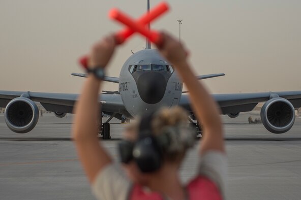 Senior Airman Clarissa Banks, a 340th Aircraft Maintenance Unit crew chief, controls the movement of a KC-135 Stratotanker prior to takeoff on Al Udeid Air Base, Qatar, April 8, 2015. Al Udeid is a strategic coalition air base in Qatar that supports over 90 combat and support aircraft and houses more than 5,000 military personnel. (U.S. Air Force photo/Senior Airman James Richardson)