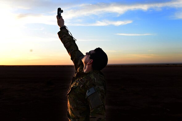 Capt. John Kauzlaric, a MC-130J Commando II combat systems officer, checks wind speed April 2, 2015, at Melrose Air Force Range, N.M. Kauzlaric participated in an exercise demonstrating the MC-130J’s ability to take off and land on remote airfields. (U.S. Air Force photo/Airman 1st Class Shelby Kay-Fantozzi)