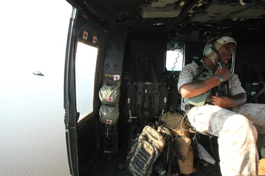Sgt. Cyrus Brown operates an AN/PRC-117 G wideband tactical radio, inside a UH-1Y Huey while flying alongside an AH-1W Super Cobra during a training exercise testing a digital interoperability system at Marine Corps Air Station Cherry Point, North Carolina, July 24, 2015. Digital interoperability is the technology capable of increasing prowess on the battlefield.  The exercise included Marine Light Attack Helicopter Squadron 467, Marine Unmanned Aerial Vehicle Squadron 2, and U.S. Marine Corps Forces, Special Operations Command, testing a LINK 16 conversion system for one of the first times within an explicitly rotary-wing exercise.  Brown is a radio operator with VMU-2.