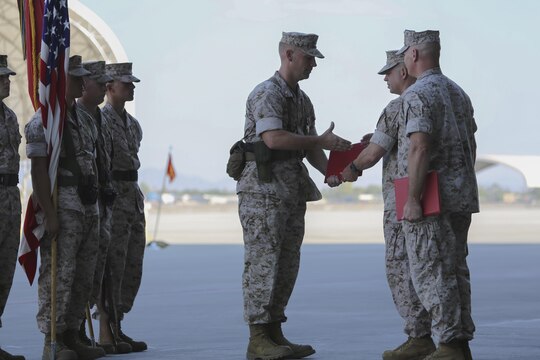 Outgoing Marine Fighter Attack Squadron 121 commanding officer, Lt. Col. Steve Gillette, receives the Meritorious Service Medal from Marine Aircraft Group 13 commanding officer, Col. Marcus Annibale, during the squadron's change of command ceremony aboard Marine Corps Air Station Yuma, Arizona, Friday, Aug. 14, 2015. Gillette, who first arrived in 2013, successfully led the Marine Corps' first F-35B squadron to achieving initial operational capability in July 2015.