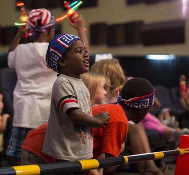 Cameron Saunders sings along with the Sesame Street performance delivered by United Services Organization Experience for Military Families at the Sakura Theater aboard Marine Corps Air Station Iwakuni, Japan, Aug. 14, 2015. The program, “Katie is Moving to a New Base,” is designed to help children of military families transition during a permanent change of station. By singing songs like “What I am” and “Everything’s A Ok,” Katie’s Sesame Street friends help her through the difficult process by highlighting the positives of relocating to a new base.