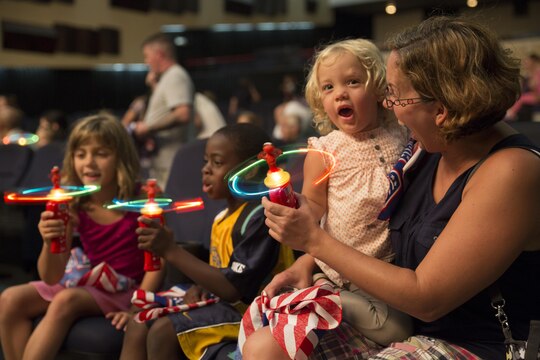Katy Corrigan, two years, and her mother Mary Corrigan, enjoy the Sesame Street performance by the United Services Organization Experience for Military Families at the Sakura Theater aboard Marine Corps Air Station Iwakuni, Japan, Aug. 14, 2015. Families in attendance received a special Sesame Street toy and reading material outlining the importance of military families adjusting to change.