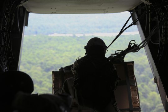 Sgt. Nicholas G. Tissandier, a crew chief with Marine Medium Tiltrotor Squadron 263, prepares to drop supplies from an MV-22 Osprey during para-operations above Marine Corps Base Camp Lejeune, N.C., Aug. 18, 2015. Two cargo loads consisting of boxes of meals, ready-to-eat and water containers were air-dropped onto Landing Zone Canary. (U.S. Marine Corps photo by Cpl. Paul S. Martinez/Released)