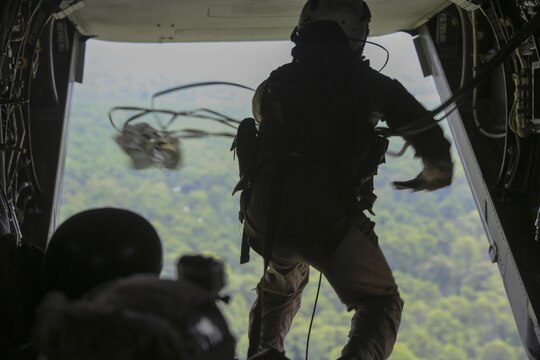 Sgt. Nicholas G. Tissandier, a crew chief with Marine Medium Tiltrotor Squadron 263, retrieves a deployment bag containing an end to a static-line aboard an MV-22 Osprey during para-operations above Marine Corps Base Camp Lejeune, N.C., Aug. 18, 2015. Two cargo loads consisting of boxes of meals, ready-to-eat and water containers were air-dropped onto Landing Zone Canary. (U.S. Marine Corps photo by Cpl. Paul S. Martinez/Released)
