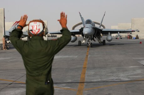 U.S. Marine plane captain with Marine Fighter Attack Squadron 232, Special Purpose Marine Air-Ground Task Force—Crisis Response—Central Command, directs an F/A-18 Hornet preparing for a strike mission in Southwest Asia, June 9, 2015. Pilots of VMFA-232 support Combined Joint Task Force—Operation Inherent Resolve with a combination of surveillance flights and kinetic strike missions, enabling Iraqi Security Forces in their fight against the Islamic State of Iraq and the Levant. (U.S. Marine Corps Photo by Cpl. Leah Agler/Released)