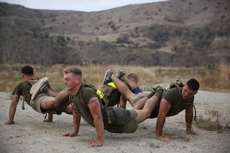 Marines assigned to Company K, 3rd Battalion, 5th Marine Regiment, 1st Marine Division, work together to complete fire team pushups as part of the Dark Horse Ajax Challenge aboard Marine Corps Base Camp Pendleton, Aug. 20, 2015. The eight-mile course tested the Marines’ and Sailors’ endurance and leadership skills with trials spread across the San Mateo area. (U.S. Marine Corps photo by Cpl. Will Perkins)