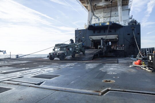 A Marine with Combat Logistics Regiment 25 drives a High Mobility Multipurpose Wheeled Vehicle (HMMWV) off of the USNS 1st Lt. Jack Lummus and onto a Roll-on/Roll-off Discharge Facility , during an in-stream Marine Prepositioning Force Exercise, Aug. 19, 2015. Marines with CLR-25 and sailors with Naval Beach Group 2 joined forces for the latest iteration of MPFEX, which saw service members offloading the Lummus using Lift-on/Lift-Off and Roll-on/Roll-off procedures off the coast of Marine Corps Support Facility Blount Island, Fla. (U.S. Marine Corps photo by Sgt. Shawn Valosin/Released)