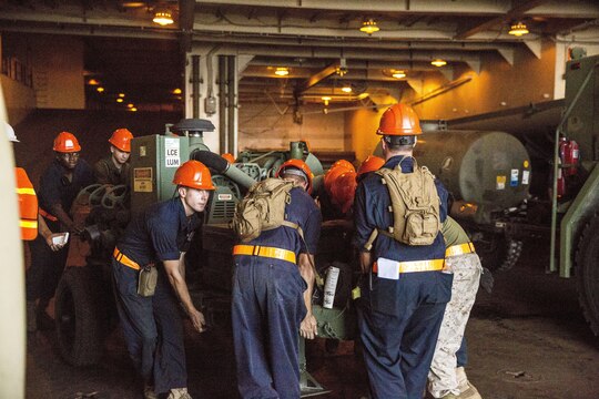 Marines with Combat Logistics Regiment 25 work together to position a trailer for offload from the USNS 1st Lt. Jack Lummus during a Marine Prepositioning Force Exercise, Aug. 19, 2015. Marines with CLR-25 and sailors with Naval Beach Group 2 joined forces for the latest iteration of MPFEX, which saw service members offloading the Lummus using Lift-on/Lift-Off and Roll-on/Roll-off procedures off the coast of Marine Corps Support Facility Blount Island, Fla. (U.S. Marine Corps photo by Sgt. Shawn Valosin/Released)
