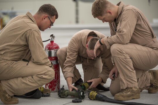 Cpl. Mason Stone, left, a KC-130J crewmaster, Staff Sgt. David Hoyt, middle, a KC-130J loadmaster, and Cpl. Greg Gambrell, a KC-130J crewmaster, set up the refueling site for air delivery ground refueling training aboard Marine Corps Air Station Iwakuni, Japan, Aug 20, 2015. Marine Aerial Refueler Transport Squadron 152 uses this training to make sure their Marines are able to proficiently use all of the KC-130J’s assets.