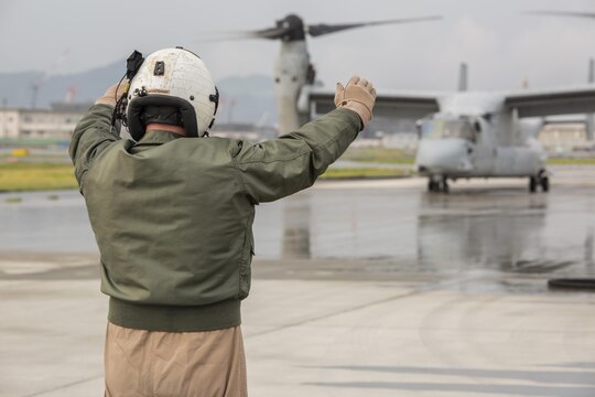 Staff Sgt. David Hoyt, a KC-130J loadmaster with Marine Aerial Refueler Transport Squadron(VMGR) 152, guides a MV-22B Osprey tiltrotor aircraft with Marine Medium Tiltrotor Squadron 262, into place for air-delivery ground refueling training aboard Marine Corps Air Station Iwakuni, Japan, Aug. 20, 2015. This kind of refueling operation is usually conducted in an austere environment where an air strip or fuel is not available. The KC-130J’s ability to refuel other vehicles adheres to the Marine Corps aviation’s mission to deliver Marines, fuel and cargo where needed.