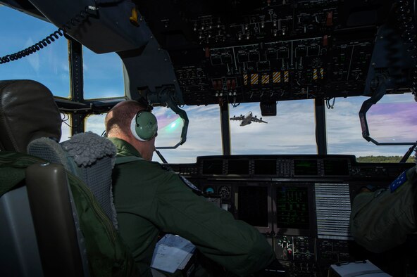 Royal Air Force Flight Lt. Graeme Hunt, a British C-130J Super Hercules pilot on exchange with the Royal Australian Air Force's No. 37 Squadron holds short of an intersecting runway while a C-17 Globemaster III performs a touch and go during Pacific Airlift Rally on Aug. 25, 2015, at Joint Base Elmendorf-Richardson, Alaska. Pacific Airlift Rally is a biennial, military airlift symposium sponsored by Pacific Air Forces for nations in the Indo-Asia-Pacific region. This year marks the 10th iteration of the PAR exercise series, which began in 1997. (U.S. Air Force photo by Staff Sgt. Sheila deVera/Released)