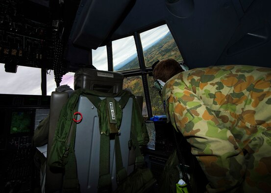 Royal Australian Air Force Lt. Andreas Constantinou and a RAAF maintainer conduct search and rescue training from a C-130J Hercules near Joint Base Elmendorf-Richardson, Alaska, Aug. 25, 2015, during Pacific Airlift Rally. PAF is a biennial, military airlift symposium sponsored by Pacific Air Forces for nations in the Indo-Asia-Pacific region.(U.S. Air Force photo by Staff Sgt. Sheila deVera/Released)