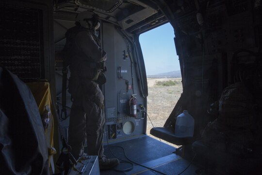 Gunnery Sgt. Paul Gallion, a flight line division chief and weapons and tactics instructor with Marine Medium Tiltrotor Squadron (VMM) 166 (Reinforced) watches as an MV-22B Osprey lands during a Tactical Recovery of Aircraft and Personnel mission aboard Marine Corps Base Camp Pendleton California, Aug. 18. Marines conducted a casualty evacuation drill as part of the 13th Marine Expeditionary Unit predeployment training. (U.S. Marine Corps photo by Sgt. Lillian Stephens/Released)