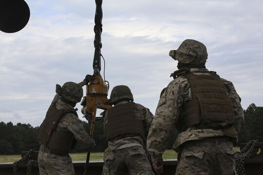 Marines with 2nd Transportation Support Battalion attach an 8,500-pound high beam to a pintle hook beneath a CH-53E Super Stallion during an external lift exercise aboard Camp Lejeune, N.C., Aug. 25, 2015. As the CH-53E hovered several yards above, on-the-ground Marines worked together to attach a beam weighing 8,500 pounds to the aircraft’s cable. (U.S. Marine Corps photo by Cpl. Paul S. Martinez/Released)