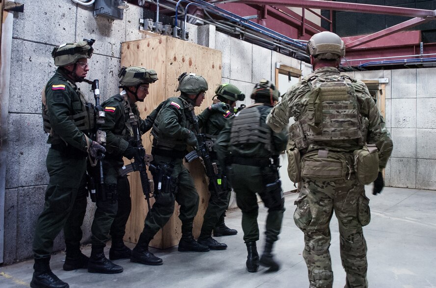 A U.S. Army Green Beret right, observes members of the Colombian Compañía Jungla Antinarcóticos simulate emplacing an explosive door-breaching charge inside a shoot house during a joint training exercise on Eglin Air Force Base, Fla., Nov. 20, 2015. U.S. Army photo by Maj. Thomas Cieslak