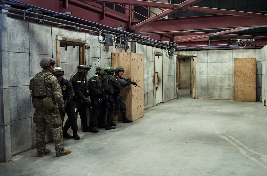 A U.S. Army Green Beret, left, observes members of the Colombian Compañía Jungla Antinarcóticos as they practice providing security during a joint training exercise on Eglin Air Force Base, Fla., Nov. 20, 2015. U.S. Army photo by Maj. Thomas Cieslak