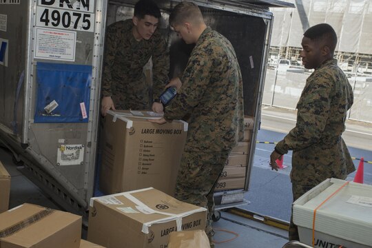 Lance Cpl. Gerardo Morales Jr., left, Pfc. Phillip Meng, middle, Pfc. Mykael Carson, right, postal clerks with Headquarters and Headquarters Squadron, unload mail at the Mainside Post Office at Marine Corps Air Station Iwakuni, Japan, Dec. 3, 2015. Despite the increased work load, postal Marines are expected to battle through this busy holiday season to ensure mail is sent and delivered on time. The postal express are mobile locations that offer opportunities for station residents to drop-off holiday mail while also meeting the U.S. postal service mailing deadlines.
