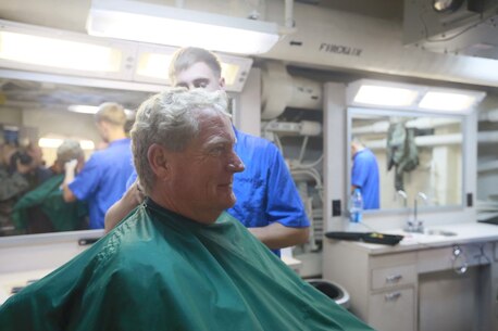 PACIFIC OCEAN (Dec. 7, 2015) U.S. Marines with 15th Marine Expeditionary Unit and family members receive haircuts in the barbershop aboard the USS Anchorage (LPD 23). The 15th MEU is coming to the end of deployment and hosting a Tiger Cruise for family members to showcase life aboard the Anchorage. (U.S. Marine Corps photo by Sgt. Steve H. Lopez/Released)