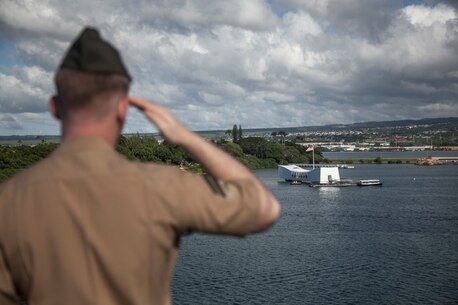 PEARL HARBOR, Hawaii (Dec. 3, 2015) A U.S. Marine with the 15th Marine Expeditionary Unit pays respect to the USS Arizona while manning the rails on the flight deck of the USS Essex (LHD-2).  Hawaii is the 15th Marine Expeditionary Unit’s last port call before heading home after their WESTPAC 15 deployment. (U.S. Marine Corps photo by Sgt. Elize McKelvey/Released)