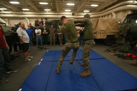 PACIFIC OCEAN (Dec. 8, 2015) U.S. Marines with Battalion Landing Team 3rd Battalion, 1st Marine Regiment, 15th Marine Expeditionary Unit demonstrate a small portion of the Marine Corps Martial Arts Program to family members in the well deck aboard the USS Anchorage (LPD 23). The 15th MEU is coming to the end of deployment and hosting a Tiger Cruise for family members to showcase life aboard the Anchorage. (U.S. Marine Corps photo by Sgt. Steve H. Lopez/Released)