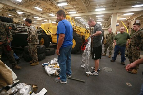 PACIFIC OCEAN (Dec. 9, 2015) U.S. Marines with Combat Logistic Battalion 15, 15th Marine Expeditionary Unit display the fire suppression system (FSS) and allow family members to get hands on experience aboard the USS Anchorage (LPD 23). The 15th MEU is coming to the end of deployment and hosting a Tiger Cruise for family members to showcase life aboard the Anchorage. (U.S. Marine Corps photo by Sgt. Steve H. Lopez/Released)