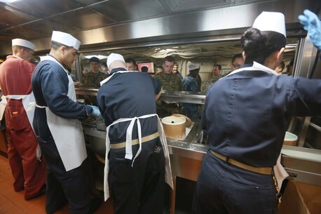 PACIFIC OCEAN (Dec. 9, 2015) U.S. Navy senior enlisted leadership serves ice cream to the Marines and Sailors with 15th Marine Expeditionary Unit and USS Anchorage (LPD 23) during an ice cream social aboard the Anchorage. The 15th MEU is coming to the end of deployment and hosting a Tiger Cruise for family members to showcase life aboard the Anchorage. (U.S. Marine Corps photo by Sgt. Steve H. Lopez/Released)