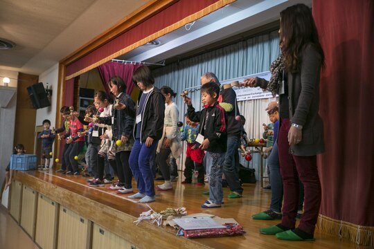 Participants practice using the kendama on stage during Cultural Day in Tsuzu, Dec. 12, 2015. This cultural exchange provides both the American and Japanese communities an opportunity to interact, learn about each other’s culture, and make new friends through a variety of activities.