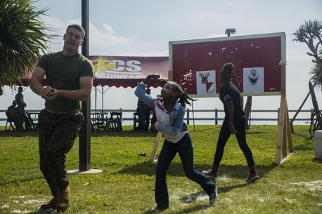 During the event, Santa’s Little Helper, Marines and children have snowball fights on Camp Hansen, Okinawa, Japan, Dec. 12, 2015. The event also had Santa fast rope out of a helicopter, a bouncy castle, face painting and food served. The event was hosted by Combat Assault Battalion, 3rd Marine Division, III Marine Expeditionary Force and Marine Corps Community Services. (U.S. Marine Corps photo by Cpl. Tyler S. Giguere/Released)