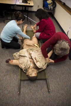 MARINE CORPS BASE CAMP PENDLETON, Calif. – Members of the base Family Advocacy Program practice applying tourniquets on a training dummy during an Improvised Sudden Attack First Emergency Response (IMSAFER) course aboard Marine Corps Base Camp Pendleton, Calif., Dec. 14. The IMSAFER training taught several life-saving techniques to use during an emergency situation.