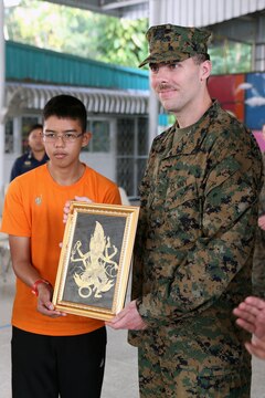 U.S. Navy Lt. Matthew Heathman receives a gift of appreciation from the Nakhon Ratchasima Panyonnookun School, February 12. Marines with 1st Marine Aircraft Wing and members of the Royal Thai Air Force volunteered at the school during Exercise Cobra Gold 2015 to spend time in the community. Heathman is the deputy Chaplain for Marine Aircraft Group 12, I Marine Aircraft Wing, III Marine Expeditionary Force, and a Madisonville, Texas, native. For more information on Exercise Cobra Gold, please visit the official Facebook page at http://www.facebook.com/ExerciseCobraGold.