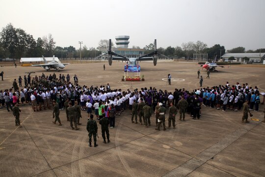 Members of the Royal Thai Air Force, U.S. Marines and Sailors, along with students and educators from the surrounding area, wait for Friendship Day to start at Royal Thai Air Force Base Korat during Exercise Cobra Gold 2015, Feb. 13. Children and educators from local schools were welcomed to the event, a joint effort by the Royal Thai Air Force and U.S. Marines, which included a display of jets, an MV-22 Osprey, a Marine Corps Martial Arts Program demonstration, a robot used for explosive ordnance disposal, and an Aircraft Rescue Firefighting truck. Cobra Gold 2015 is a Thailand /United States co-sponsored, multinational and joint theater security cooperation exercise, conducted annually in the Kingdom of Thailand, with 25 nations participating. This year there is an increased focus on Humanitarian Civic Action, community engagement and medical activities to support the needs and humanitarian interests of civilian populations around the region. For more information on exercise Cobra Gold, please visit the official Facebook page at http://www.facebook.com/ExerciseCobraGold.