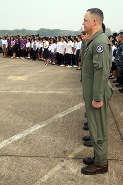 Lt. Col. Keith Topel, executive officer for Marine Aircraft Group 12, 1st Marine Aircraft Wing, III Marine Expeditionary Force, stands with service members and students from local schools during the opening ceremony for Friendship Day, an open house event held by Royal Thai Air Force Wing 1 and U.S. Marines at Royal Thai Air Force Base Korat Feb. 13 during Exercise Cobra Gold 2015. Children and educators from local schools were welcomed to the event, a joint effort by both militaries, which included a display of jets, an MV-22 Osprey, a Marine Corps Martial Arts Program demonstration, a robot used for explosive ordnance disposal, and an Aircraft Rescue Firefighting truck. Cobra Gold 2015 is a Thailand /United States co-sponsored, multinational and joint theater security cooperation exercise, conducted annually in the Kingdom of Thailand, with 25 nations participating. This year there is an increased focus on Humanitarian Civic Action, community engagement, and medical activities to support the needs and humanitarian interests of civilian populations around the region. For more information on exercise Cobra Gold, please visit the official Facebook page at http://www.facebook.com/ExerciseCobraGold.