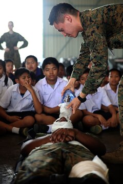 U.S. Navy Corpsmen show children from Yothinnukun School how to treat a casualty during Friendship Day held by Royal Thai Air Force Wing 1 and U.S. Marines at Royal Thai Air Force Base Korat during Exercise Cobra Gold 2015, Feb. 13. Students observed demonstrations of the Marine Corps Martial Arts Program, Explosive Ordnance Disposal, Aircraft Rescue Firefighting, and Navy Corpsmen basic medical procedures. Cobra Gold 2015 is a Thailand /United States co-sponsored, multinational and joint theater security cooperation exercise, conducted annually in the Kingdom of Thailand, with 25 nations participating. This year there is an increased focus on Humanitarian Civic Action, community engagement, and medical activities to support the needs and humanitarian interests of civilian populations around the region. For more information on exercise Cobra Gold, please visit the official Facebook page at http://www.facebook.com/ExerciseCobraGold.