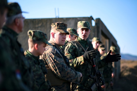 Lance Cpl. Ognjen Samolovac, a sniper with the Serbian Army, helps translate a review of the squad’s performance at the conclusion of a scenario in military operations on urbanized terrain. Serbians conducted MOUT training with Marines at Novo Selo training area in Bulgaria, Jan. 17, 2015, as part of Exercise Platinum Lion.