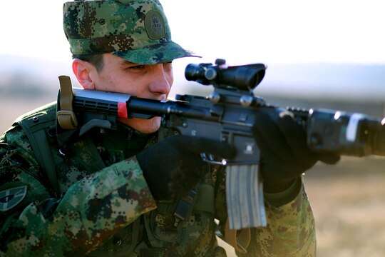 Lance Cpl. Ognjen Samolovac, a sniper with the Serbian Army, provides security as Marines breach a doorway at the military operations on urbanized terrain course. Serbians conducted MOUT training with Marines at Novo Selo training area in Bulgaria, Jan. 17, 2015, as part of Exercise Platinum Lion.