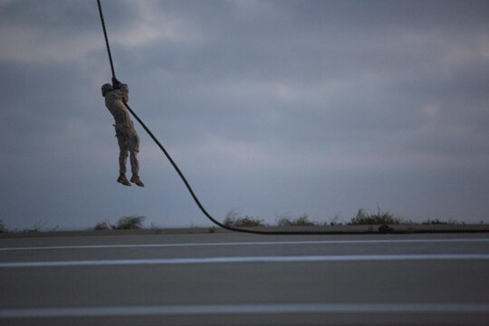 An infantry Marine from Golf Company, Battalion Landing Team 2nd Battalion, 1st Marine Regiment fast ropes from a CH-53E Super Stallion on Marine Corps Base Camp Pendleton, California, July 2. The helicopter pilots maintained a steady hover over the landing area as infantry Marines fast roped from a trap door in the bottom of the aircraft. (U.S. Marine Corps photo by Sgt. Lillian Stephens/Released)