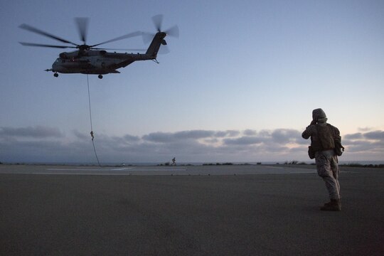 Marines from Golf Company, Battalion Landing Team 2nd Battalion, 1st Marine Regiment fast rope from a CH-53E Super Stallion on Marine Corps Base Camp Pendleton, California, July 2. The helicopter pilots maintained a steady hover while Marines fast-roped to the ground below. (U.S. Marine Corps photo by Sgt. Lillian Stephens/Released)