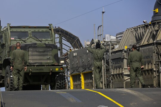 U.S. Navy Landing Craft Air Cushioned (LCAC) vehicle from Assault Craft Unit 5 unloads a U.S. Marine Medium Tactical Vehicle Replacement onto Red Beach as part of a loading exercise along side Combat Logistics Battalion 11, Headquarters Regiment, 1st Marine Logistics Group aboard Camp Pendleton, Calif., June 23, 2015. This loading exercise reinforces the Marine Corps role as an amphibious force in readiness by maintaining capabilities through realistic training. (U.S. Marine Corps photo by Lance Cpl. Lauren Falk/Released)