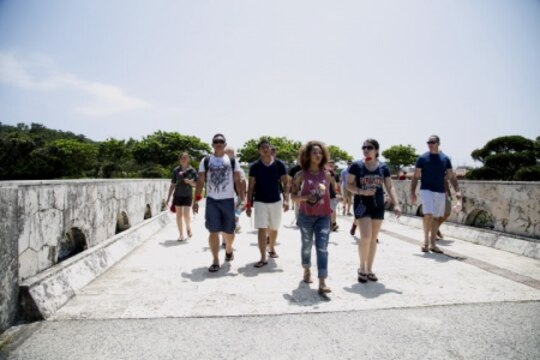 Volunteers with the United Service Organizations, Okinawa make their way along Memorial Path June 27 at Peace Memorial Park, Itoman City, Japan. They walked to the large granite epitaphs inscribed with the names of those killed during the 90-day Battle of Okinawa. Volunteers laid roses at their base of in remembrance of those lost. (U.S. Marine Corps Photo by Lance Cpl. Jessica Collins/Released)