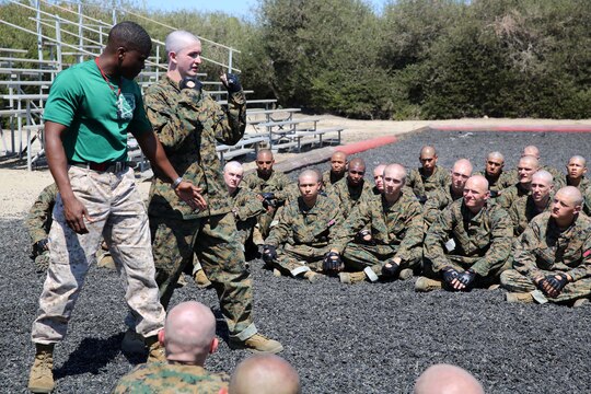 Staff Sgt. Brandon J. Curry, Marine Corps Martial Arts Instructor, Support Battalion, uses a recruit to give a visual demonstration of correct hand placement when striking during a MCMAP class at Marine Corps Recruit Depot San Diego, July 15. Recruits receive multiple MCMAP classes throughout recruit training and are given a MCMAP test on training day 50 to verify their knowledge of MCMAP fundamentals.