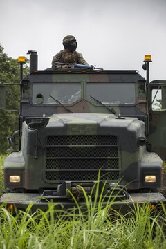 Sgt. Paul D. Johnis, a ground radio repairman with Combat Logistics Company 36, posts security in the gunner’s seat of an AMK-27 medium tactical vehicle during Exercise Dragon Fire 2015 at Combined Arms Training Center Camp Fuji, Japan, July 24. During the convoy and recovery operation portion of this exercise, Marines and Sailors learned to post 360 degree security, foot patrolling and the immediate action for responding to enemy fire. Allowing service members to practice real life scenarios aided in combat mindset development to prepare them for the mental and physical stress of a combat zone. CLC-36 conducts this exercise annually to make their service members a little more combat ready by recapping the basic skills they learn in boot camp or Marine combat training.