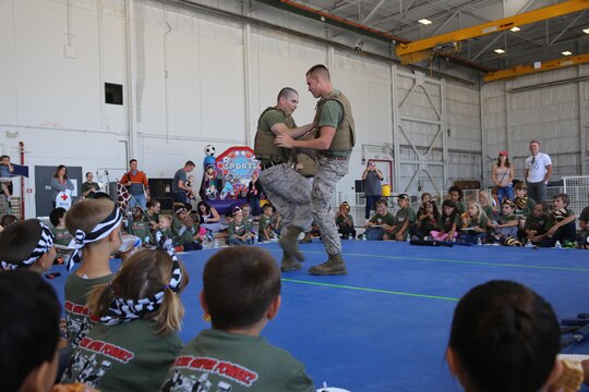 Marines with Marine Aircraft Group (MAG) 16 show off their martial arts skill to the children of service members at Junior Jarhead Day aboard Marine Corps Air Station Miramar, California, June 6. The Marines demonstrated techniques used in the Marine Corps Martial Arts Program.  (U.S. Marine Corps photo by Lance Cpl. Kimberlyn D. Adams/Released)