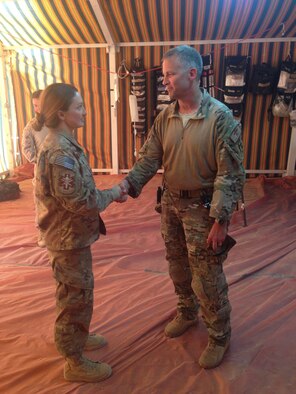 U.S. Air Force Capt. Erin Mai, 379th Expeditionary Medical Group physician is coined by Maj. Gen. Rick Mattson, U.S. Central Command Exercises and Training director, on behalf of the Mobile Forward Surgical Team/Expeditionary Critical Care team for resuscitating a British soldier during exercise Eager Lion, May 10, 2015.  MFST/ECCT teams play a critical role in the Central Command Area of Responsibility with their rapid medical response capability. (Courtesy photo)